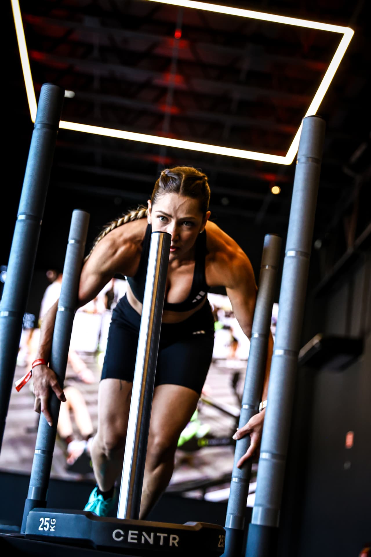 Atleta de trança empurrando o sled Centr