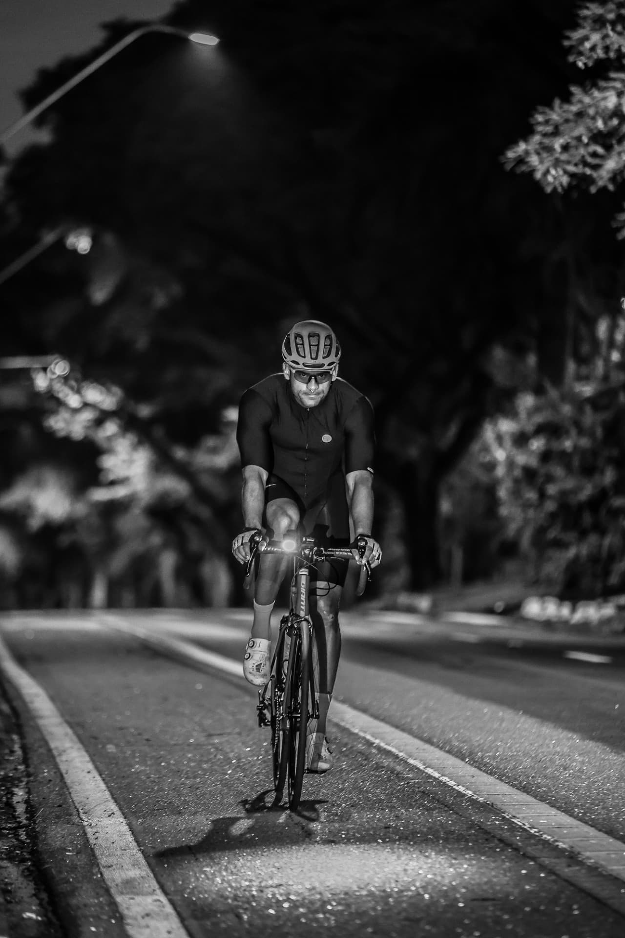 Ciclista pedalando à noite, em preto e branco