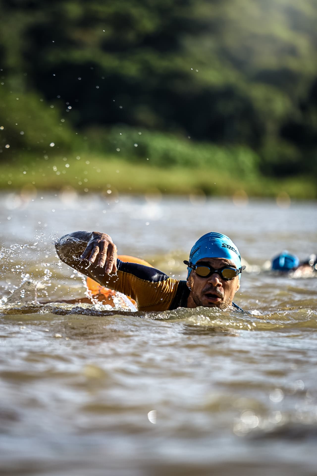 Triatleta nadando em águas abertas, braço estendido