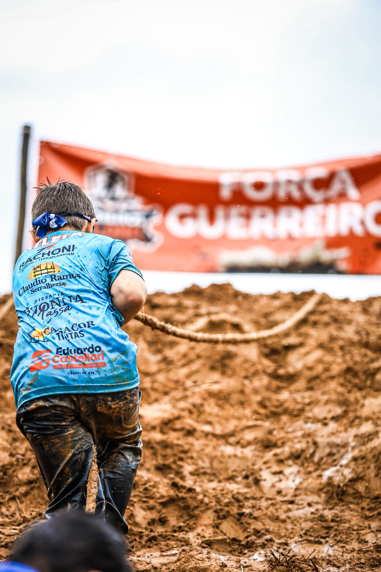 Menino puxando a corda na subida de terra