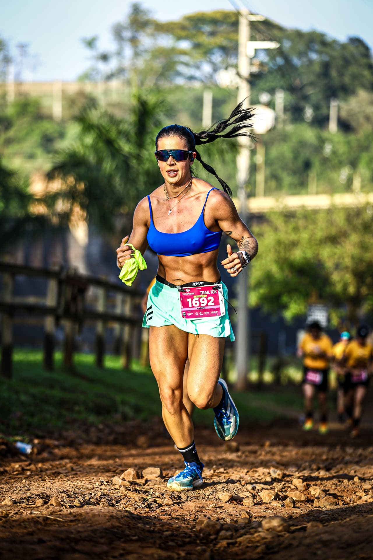 Corredora de trail 10K acelerando na terra batida