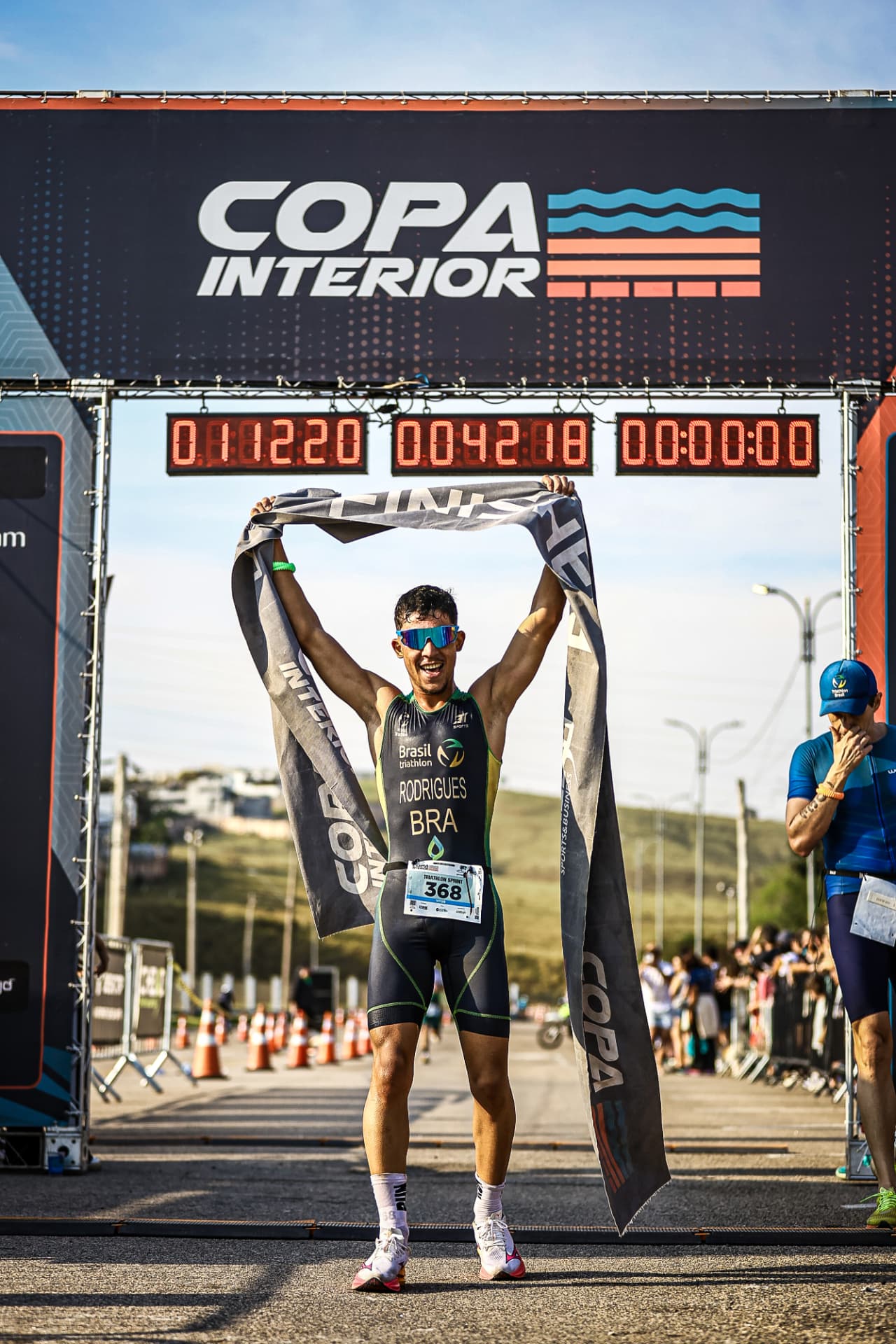 Triatleta cruzando a chegada da Copa Interior de mãos dadas com a filha