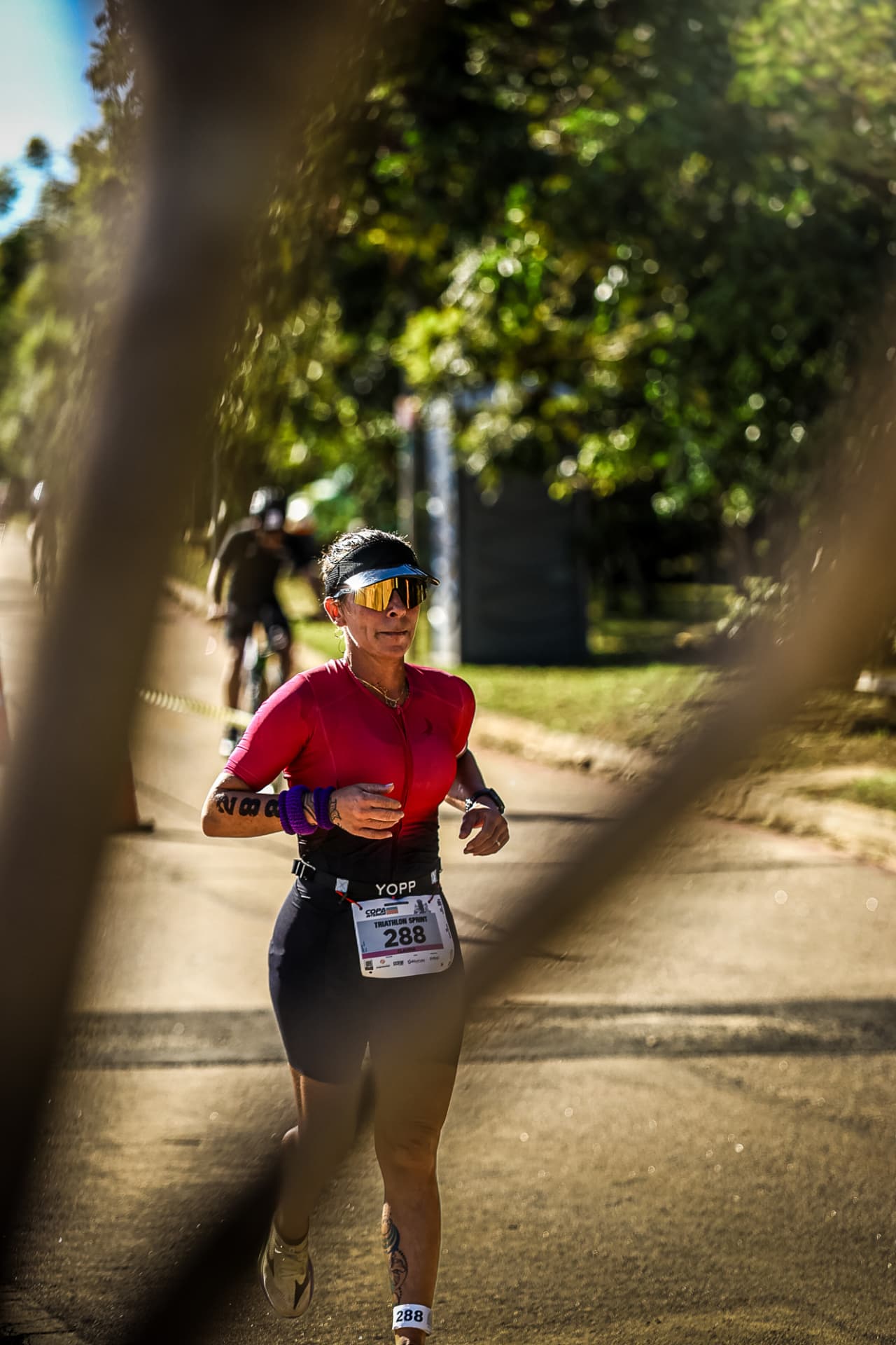 Triatleta correndo em prova cercada por vegetação