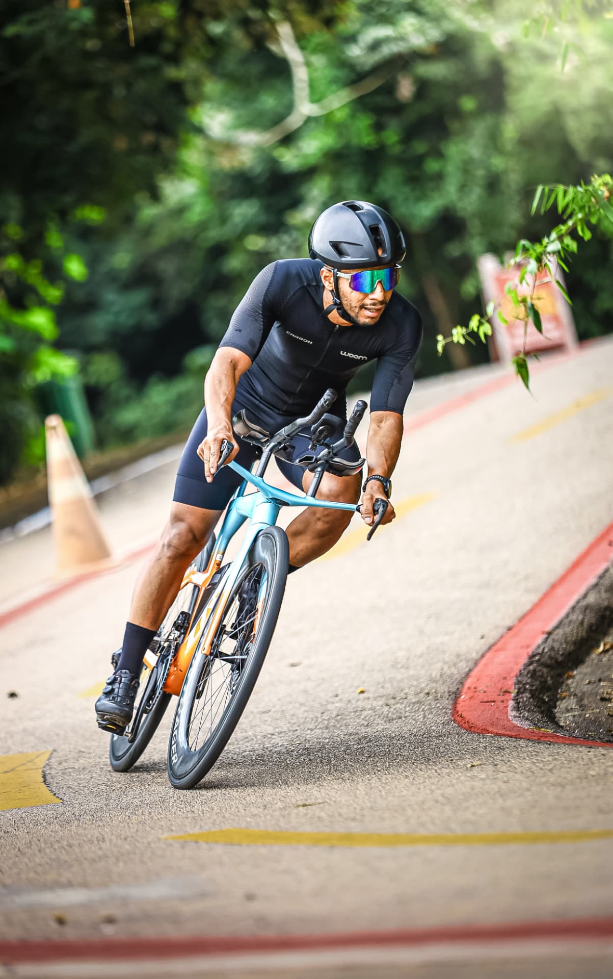 Triatleta de bike laranja em pista de ciclismo