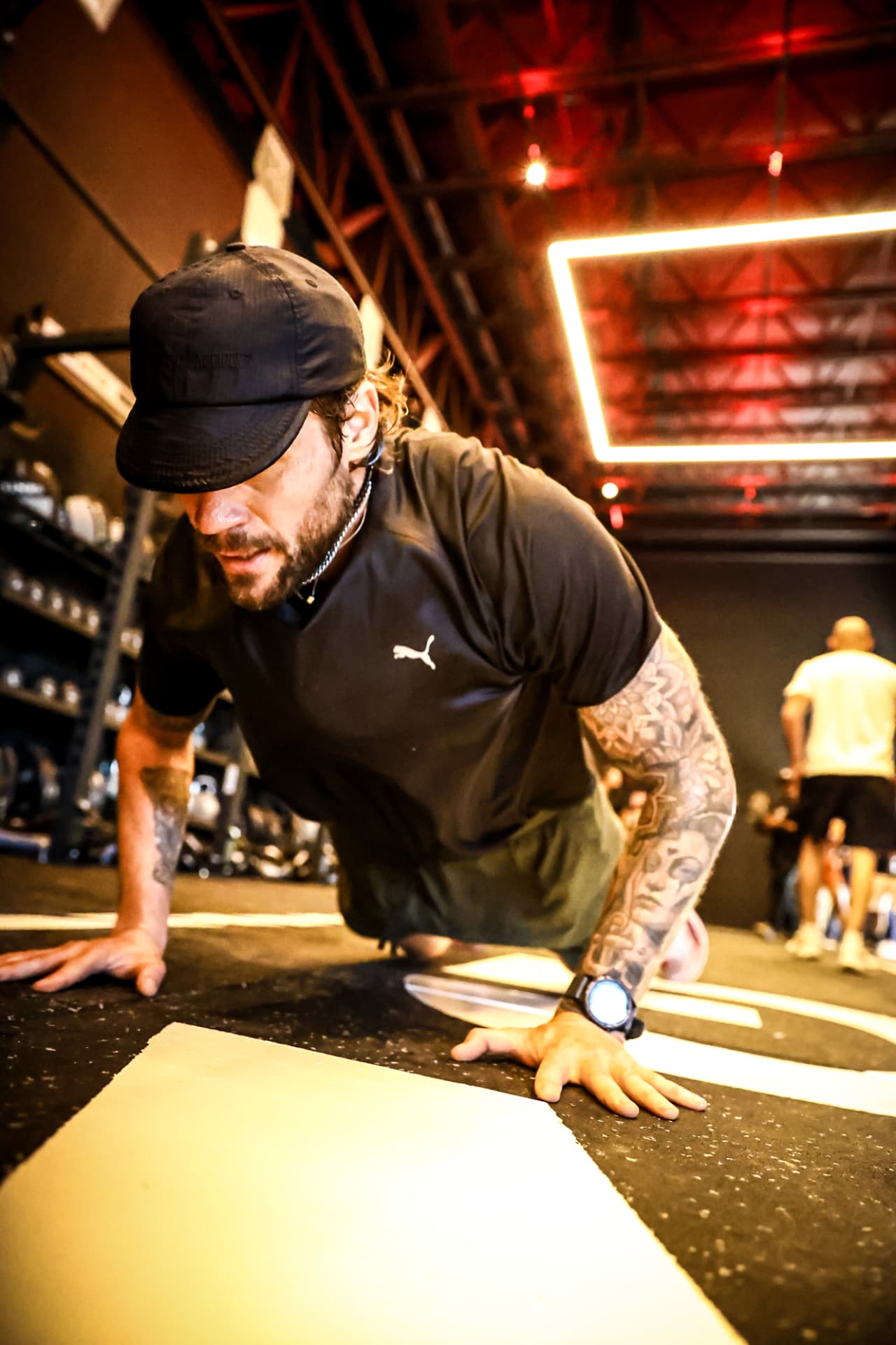 Atleta em flexão de braços no piso da arena
